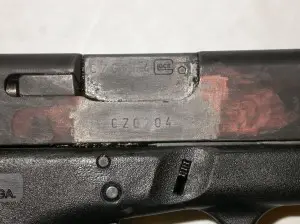 Glock showing a serial number that was restored despite having been ground off.