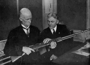 John M. Browning in 1921 with Mr Burton of Winchester and the category-creating Browning Automatic Rifle.