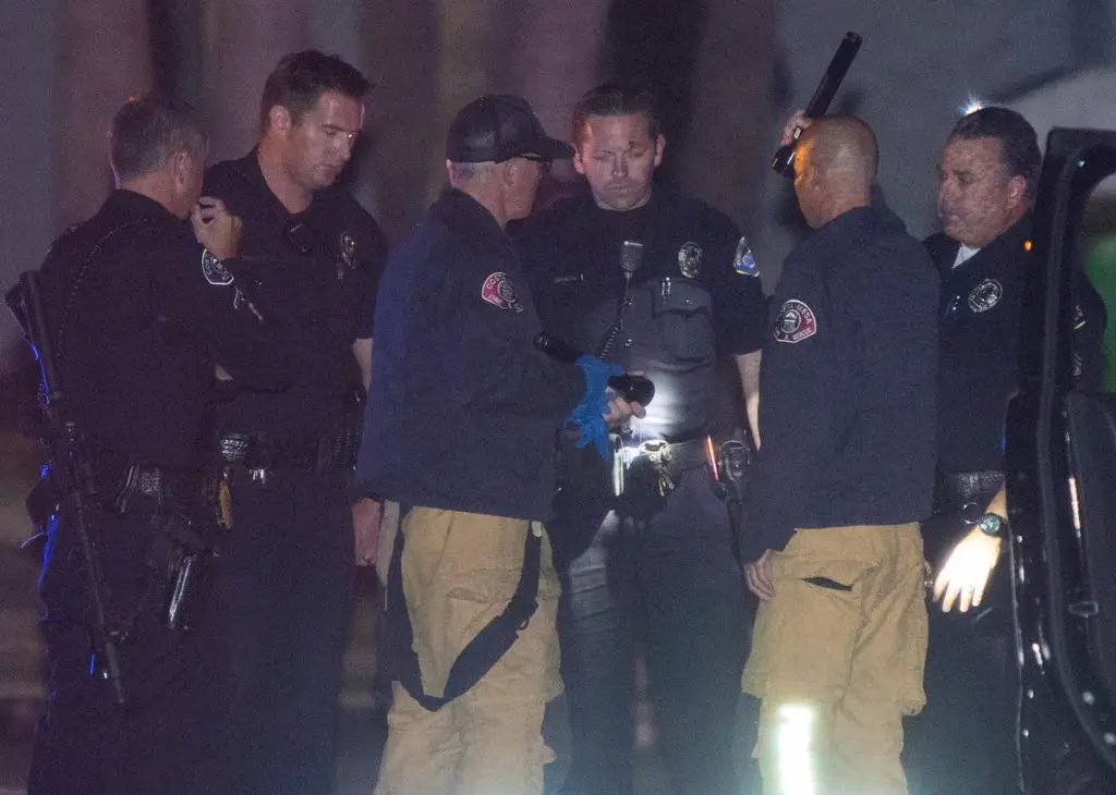 A Huntington Beach Police officer is checked out by Costa Mesa Fire after being shot in his badge during a vehicle pursuit of a suspect. The pursuit ended on the Northbound 15 Freeway when the suspect lost control of his vehicle at Cleghorn Road bursting into flames and killing him around 1:30 a.m. Friday morning in San Bernardino County.