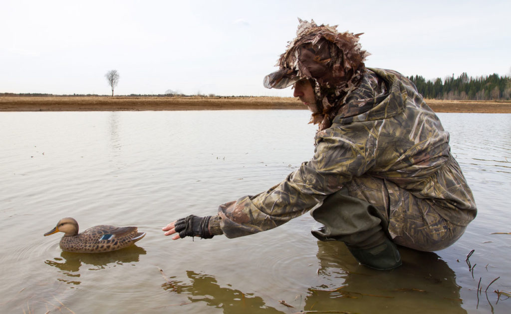 Man in the water grabbing a duck while hunting